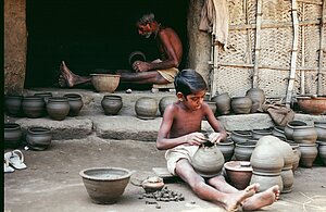 Potter Brundaban Bisoi trains a young boy from another household in the community. Tikarapada, 1980.