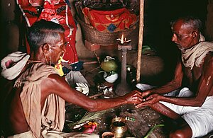 Brahmin priest guides potter Hadibandhu Bishoi in ritual inside workshop, first day of Kurala Panchami. Tikarapada, 1980.